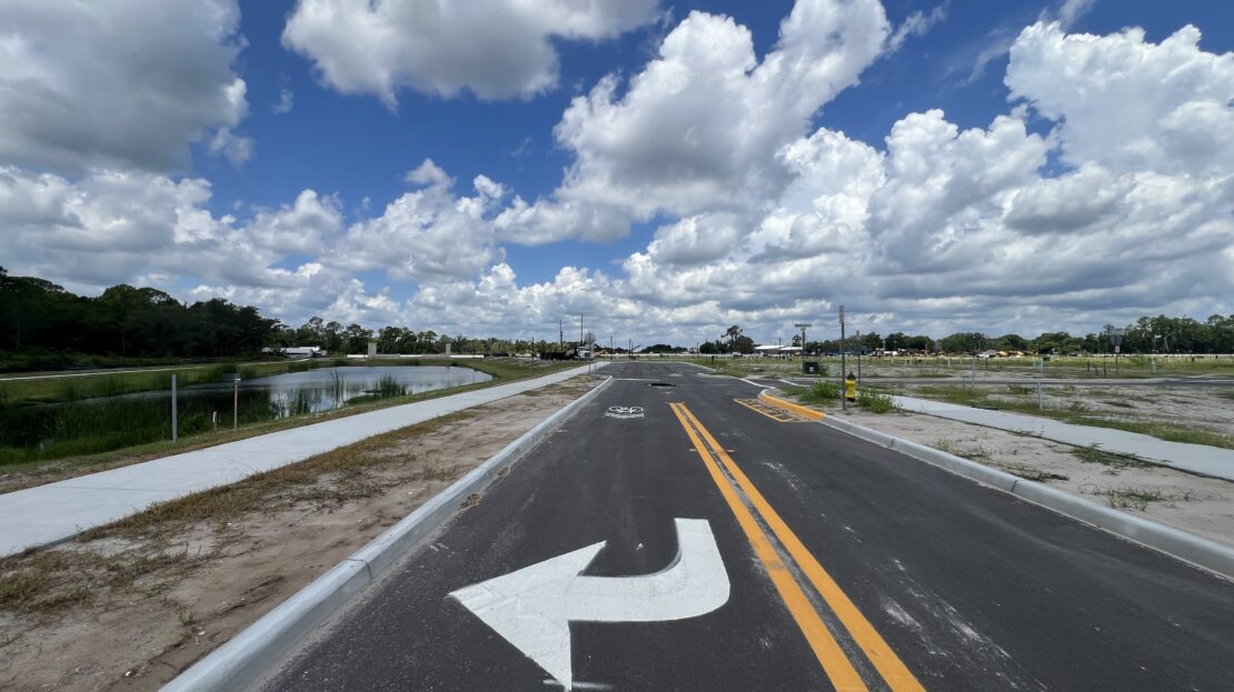 DeBary Main Street construction progress showing new roadway and stormwater pond near Shell Road