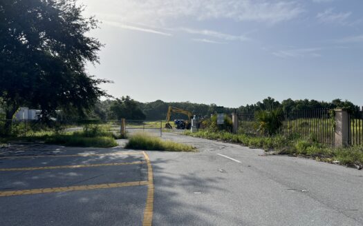 Excavator staged at the former Flea World site in Sanford FL ahead of the Reagan Center redevelopment