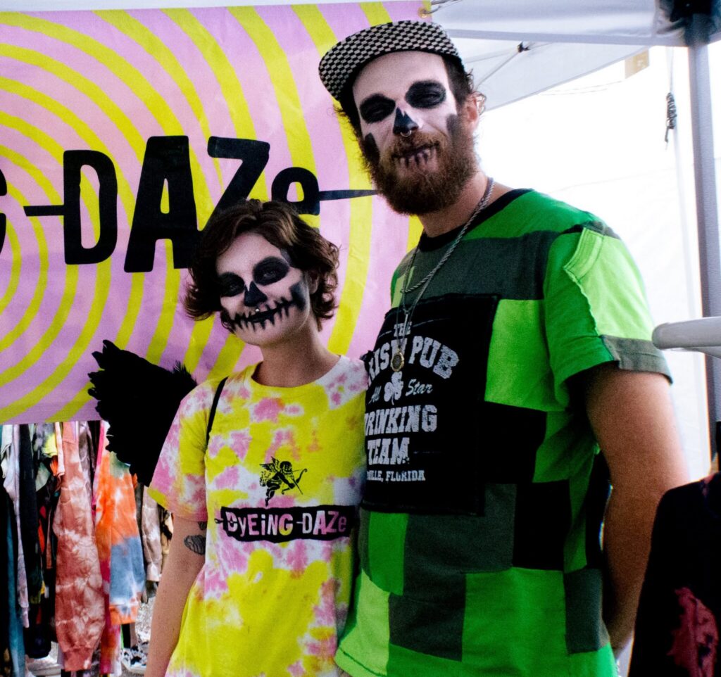 Two festival-goers in skull face paint at a Milk Mart event in Orlando's Milk District